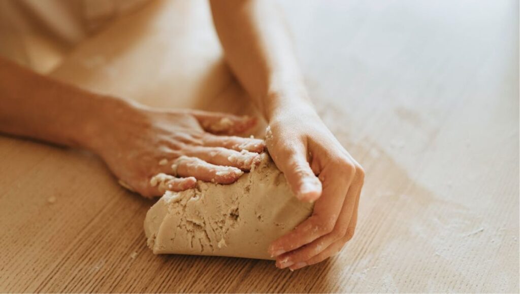amish woman kneading dough for baking bread