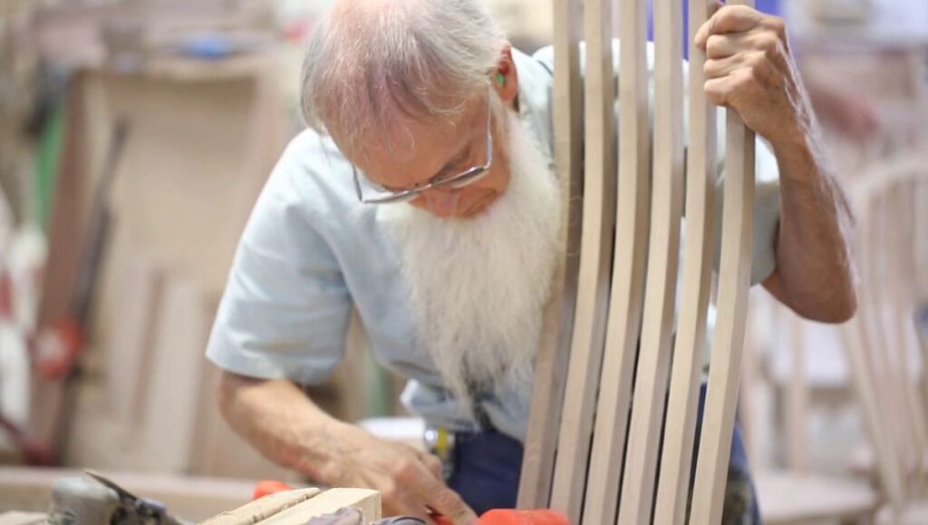 An Amish man making a furniture.
