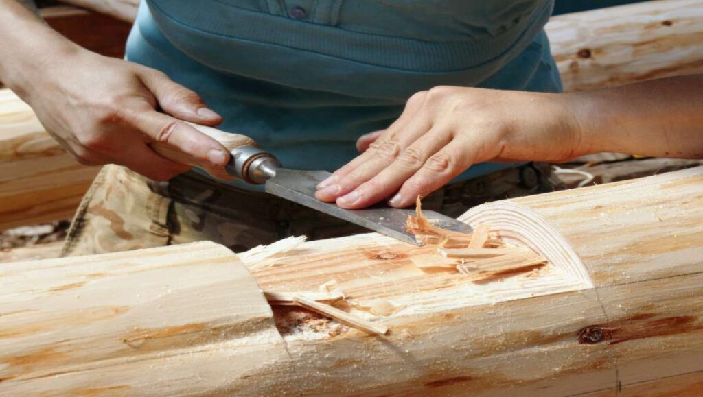 A furniture maker carving a wood.