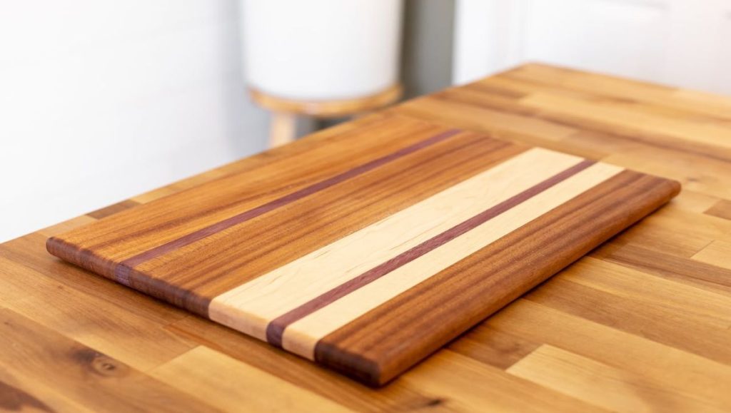 A hard maple stain chopping board on top of table
