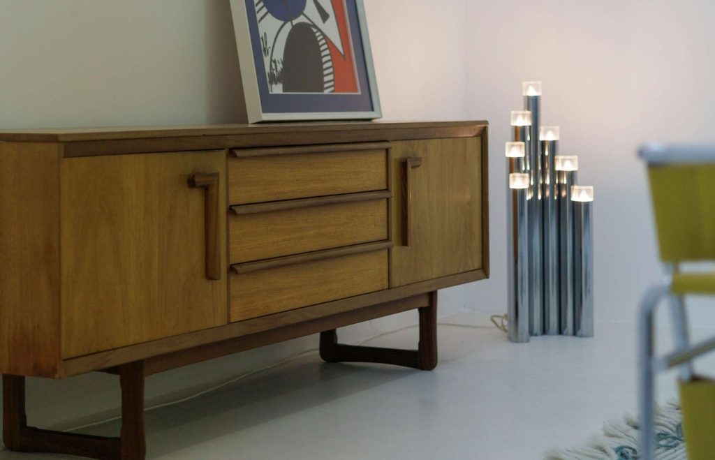 A sideboard with frame on top and lights beside