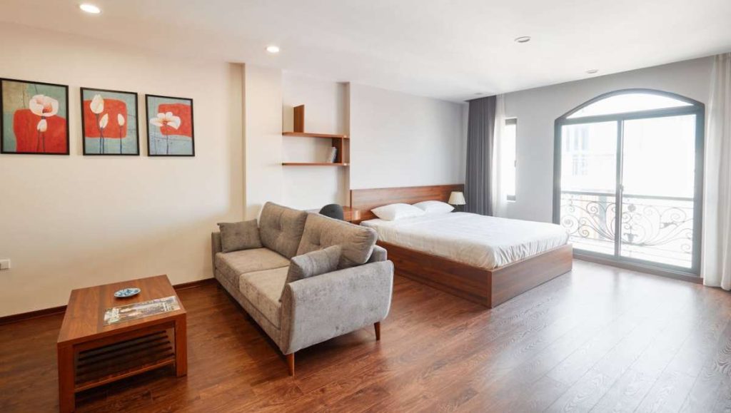 Condo with wooden bed, couch, and table