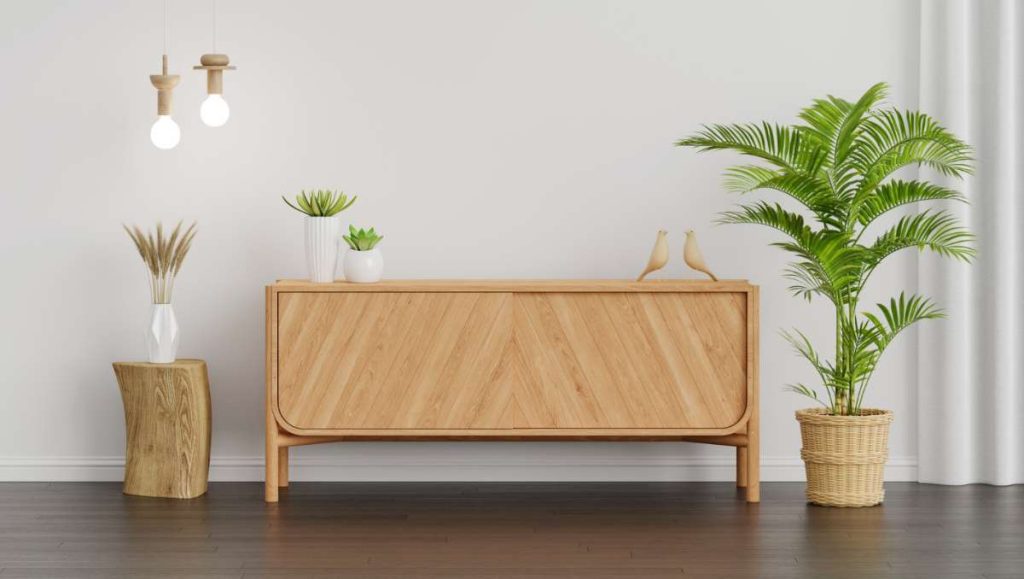 A sideboard with plants and lights beside